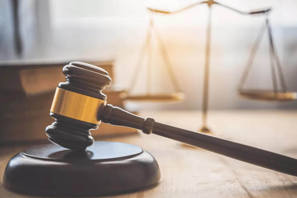 Молоток судьи на фоне весов