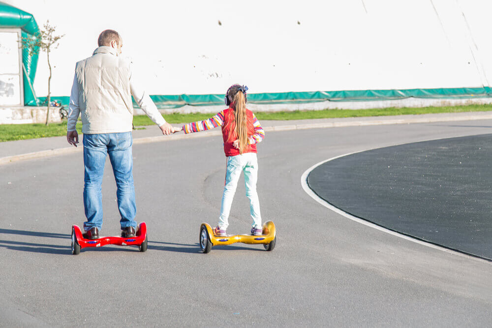 Отец и дочь катаются на гироскутерах